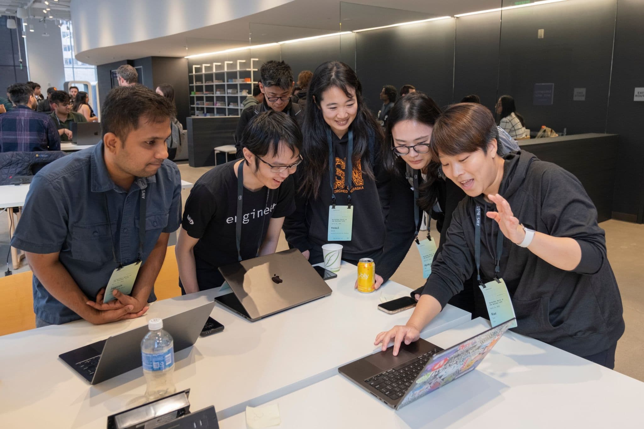 Developers gathered around a laptop during a hands-on build session.