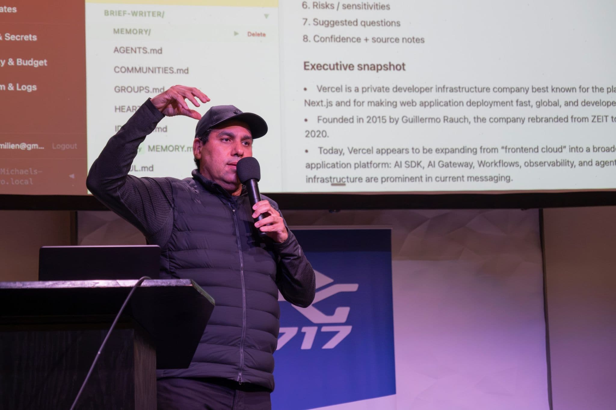 Speaker presenting a technical session with product research notes on screen.